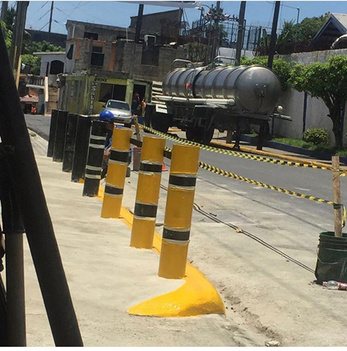Pilotillos pintados en amarillo y negro junto a la acera